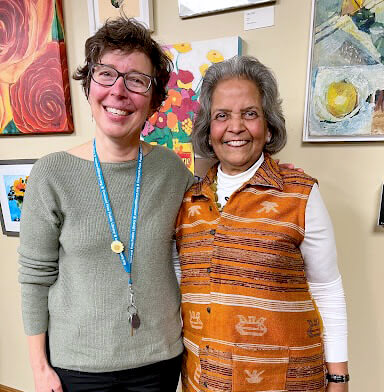 Fowler staffer Laura Mills stands with Radha Jalan in front of the art exhibition at the Fowler Branch Library.