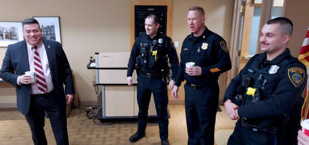 Chief Joseph O'Connor, left, shares a light moment with Department members. (Photo Courte- sy Concord Police Department)