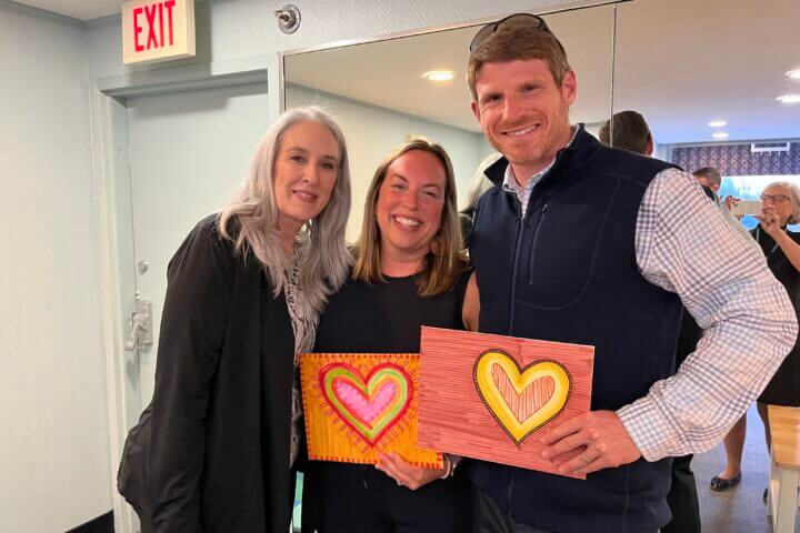 Gail Burr, center, shows painted hearts with Lynne Gaines of Horizons for Homeless Children, and Matt Burr.